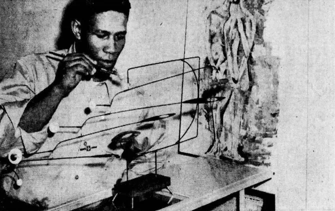 Zeitungsfoto von 1956: Leutnant Ronald E. Johnson über einem Drahtmobile, dahinter eine Figurenplastik