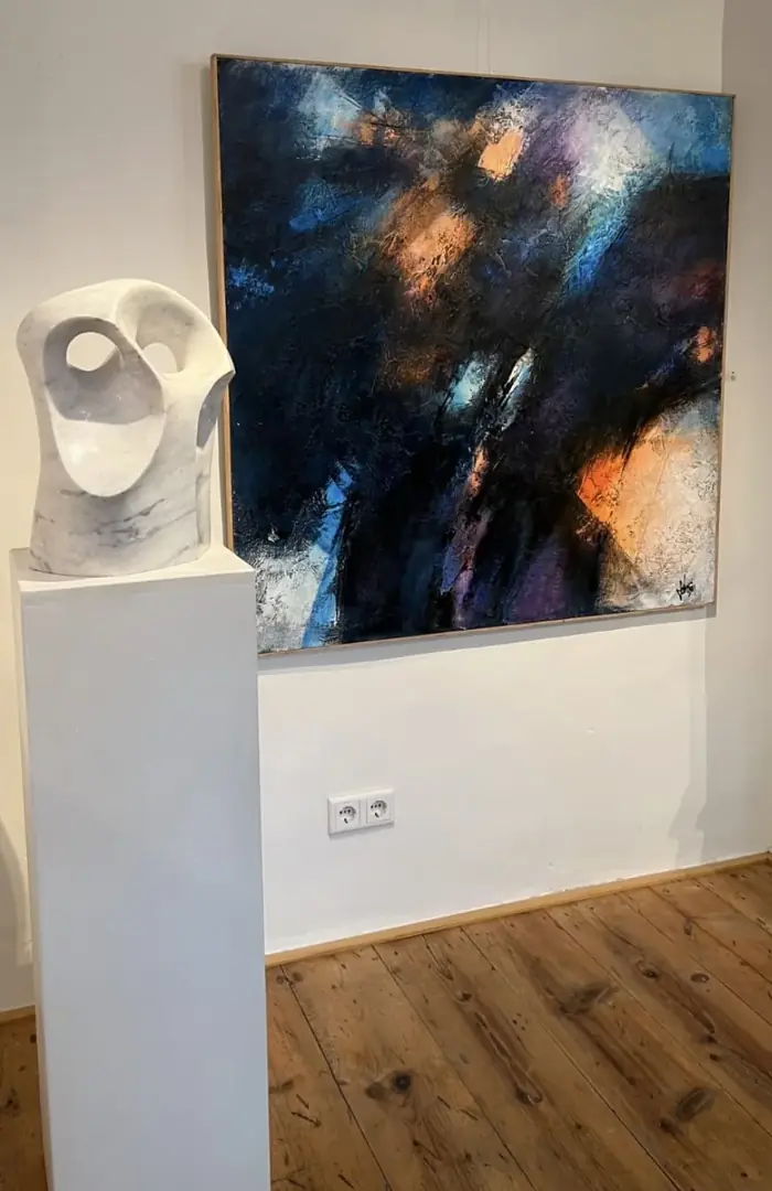 Dunkelblaues Gemälde an einer weißen Wand, davor eine weiße Marmorskulptur auf einem Sockel