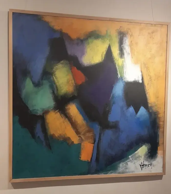 Gemälde mit Farbfeldern in Blau, Gelb, Grün und Orange an einer hellen Wand