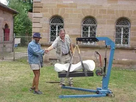 Johnson im Hof von Schloss Burgfarrnbach beim Aufbau, eine weiße Marmorskulptur hängt an einem Kran